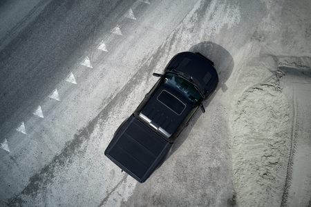 big black matt American pickup truck staying after drifting on the asphalt with tire marks
