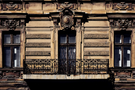Building facade of old historic house with classic antique arch window and small cozy balconyの写真素材