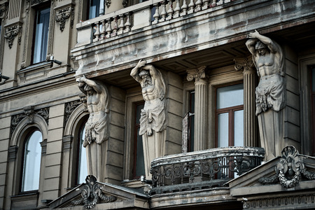 Strong Atlants is supporting balcony on the facade of historical building in Saint-Petersburg, Russiaの写真素材