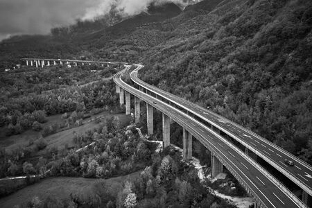 black and withe photo of alpine speed road in Italia. Aerial view from above with clouds on the backgroundの写真素材