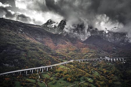 High autumn alpine speed road in Italia. Aerial view from above with clouds on the backgroundの写真素材