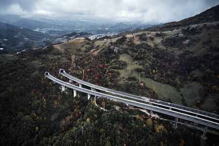 High autumn alpine speed road in Italia with exit or enter into the tunnel. Aerial view from above.の写真素材