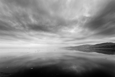landscape with frozen lake and black cloudsの写真素材
