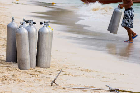 A collection of scuba divers air taks on a tropical white sand beach.の写真素材