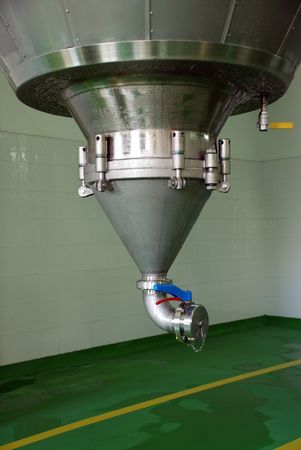 Bottom end of very large stainless steel tank of beer.