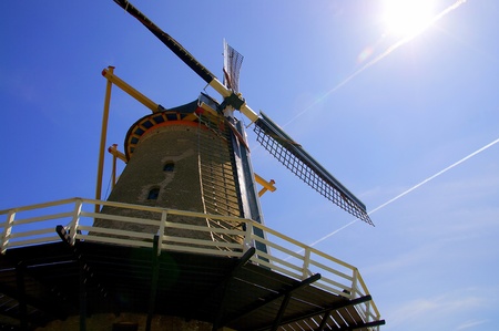 Old windmill in the blue sky with the sunの写真素材