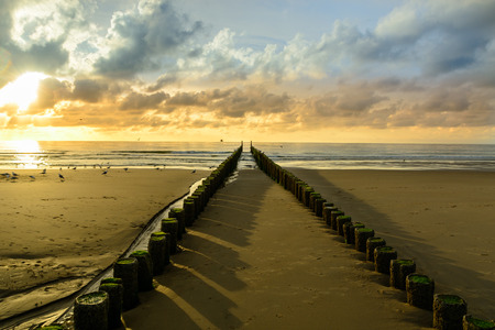 Breakwaters on the beach at sunset in Domburg, Zeeland,  Hollandの写真素材