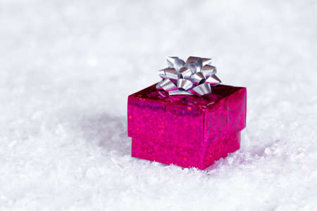 gift box with a silver bow on the snow