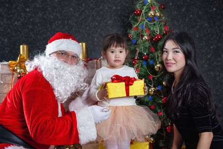 Santa Claus and mother with your child dress. Christmas Scenes. The Child holding gift box Packedの写真素材