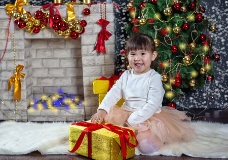 Little asean girl unleashes the gift. Christmas Scenes. Posing smilingの写真素材