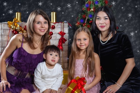 Lesbian interracial family in the background of Christmas. Two moms with their daughters.の写真素材