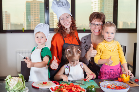 Three cute kids are preparing a salad in the kitchen. Healthy eatingの写真素材