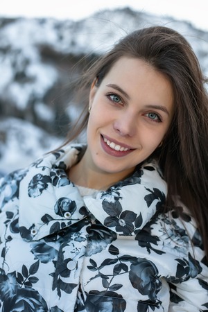 Pretty woman ice skating winter outdoors, smiling facial. Close-up outdoors, mountains in the backgroundの写真素材