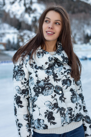 Pretty woman ice skating winter outdoors, smiling facial. Close-up outdoors, mountains in the backgroundの写真素材