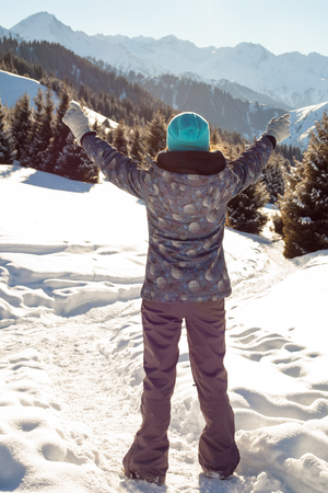 Girl stands mountain top at sunset. Mountains in the backgroundの写真素材