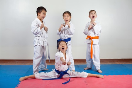 Four children demonstrate martial arts working together. Fighting position, active lifestyle, practicing fighting techniquesの写真素材