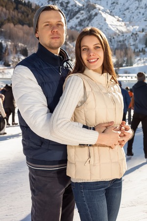Loving couple skating together holding hands. Mountains in the backgroundの写真素材