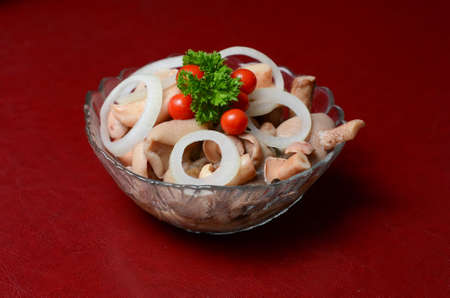 Mushrooms belong to a plate on the table. They are decorated with parsley, tomatoes and onions.;の写真素材