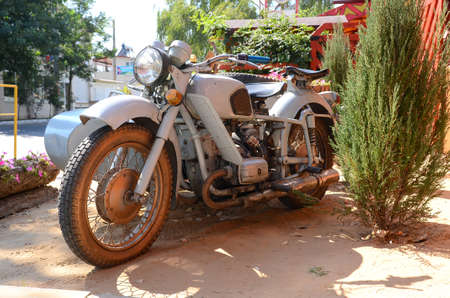 old Soviet motorcycle stands on the street. It has a gray color.の写真素材