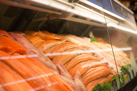 Fresh fish stacked for sale at the fish counter in the grocery store.の写真素材
