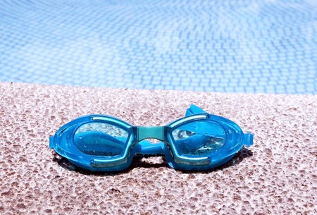 pair of blue goggles by the pool side - horizontalの写真素材