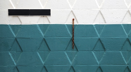 colored wall with blank sign and old chain