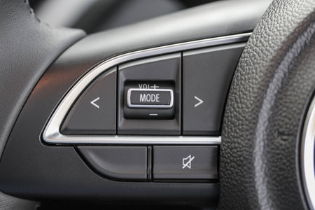 Close-up of audio buttons on a new car steering wheel.