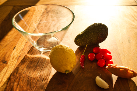 Ingredients for a guacamole. Chili, lemon, onion and avocado on a wooden table. Homemade Mexican food.の写真素材
