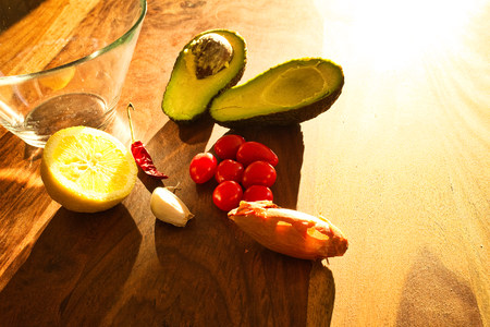 Ingredients for a guacamole. Chili, lemon, onion and avocado on a wooden table. Homemade Mexican...