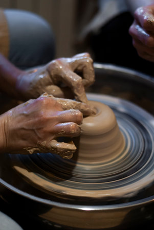 hands of a potter, creating an earthen jar on the circle