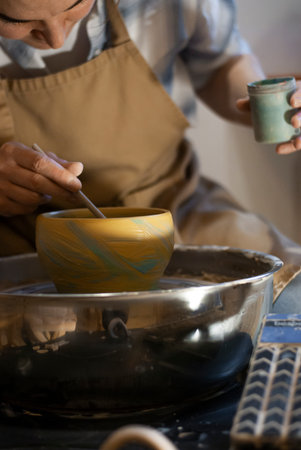 Female potter mixing clay in pottery workshop, close-upの写真素材