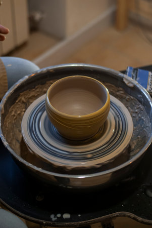 Potter working on a potter's wheel in a pottery workshop