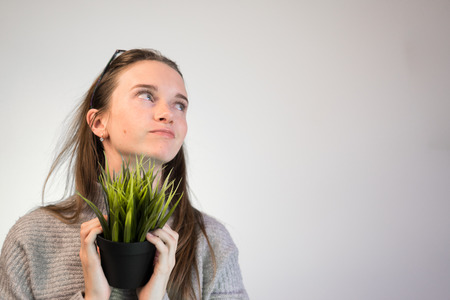 office worker with a plant in his hands and looking upの写真素材