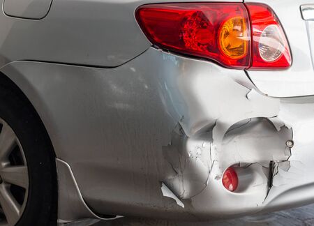 Behind the car damaged by a car crash on the roadの写真素材