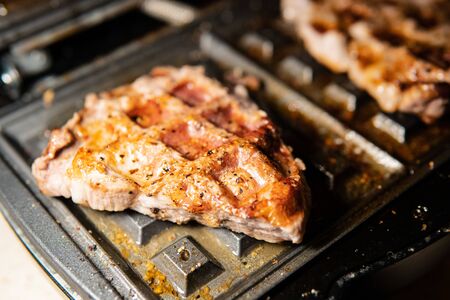 We cook barbecue at home, serve food, glisten meat in the grill with fat, cook for the festive table, roast pork in Russianの写真素材