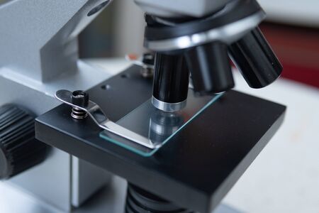 Microscope on white and red background close frame