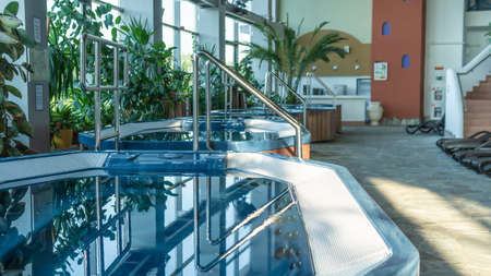 Hot tub small pool brown sun loungers Standing water hydromassage shooting in the afternoon summer heat RUSSIA, MOSCOW - AUG 23, 2020のeditorial素材