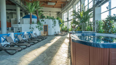 Hot tub pool for family brown sun loungers hydromassage calm in the water glistens water from the sun. RUSSIA, MOSCOW - AUG 23, 2020のeditorial素材