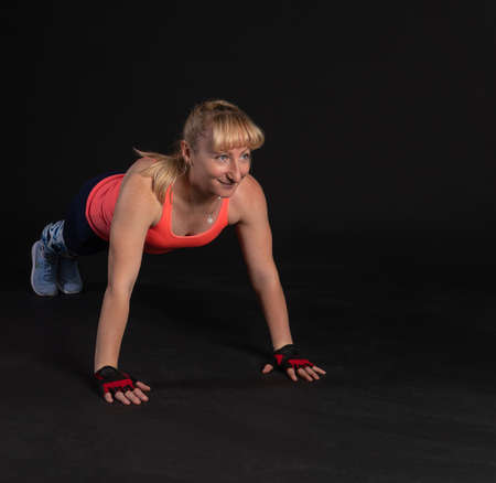 Fitness on a step platform with a barbell with dumbbells. Going in for sports on a black background...