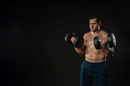 Man strains muscles with dumbbells pumps bicep bare torso Young male business Caucasian beautiful,...