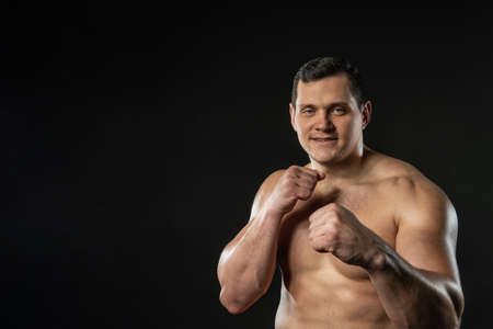 Boxer stands in the rack on the black strong male adult man, attractive background. dumbbells...