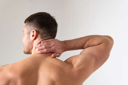 The muscles of the neck in a man on a white background are hurt back painful, person massage adult, hand therapy, lower suffer attractiveの写真素材