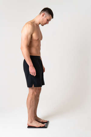 Man with weights health pondered, health and sports on a white background hurt painful, backache spine isolated young stress, hand holding. Tension red therapy, back suffer attractiveの写真素材