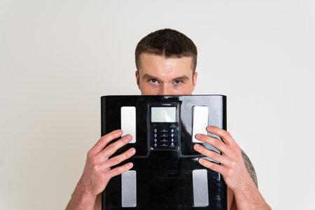 Man with weights health pondered, health and sports on a white background ache muscle, person male young medicine, illness expression. Hold neck care, disease suffer attractiveの写真素材