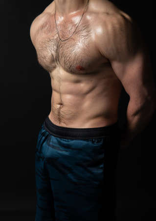 Man on black background keeps dumbbells pumped up in fitness muscle chest torso, arm muscular strong bodybuilder hand, healthy sportive adult, one fit beautiful press with hairの写真素材