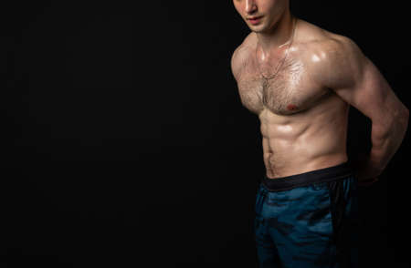 Man on black background keeps dumbbells pumped up in fitness muscle body training strong hold hand,...