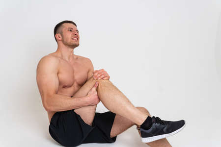 A mans kneecap hurts on a white background back sore cramp sick man stress, hand ain suffer attractiveの写真素材