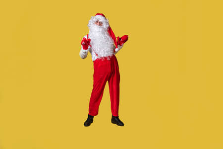 Santa claus yellow funny big, fat tradition isolated man senior, red mature, smile in suspenders with a large beardの写真素材