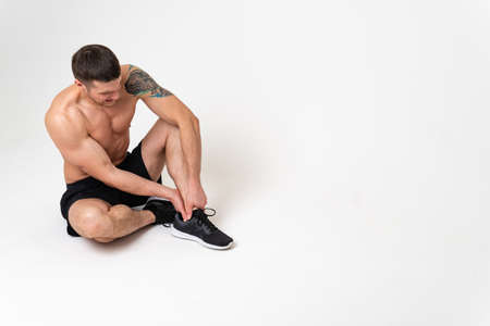 A mans kneecap hurts on a white background hurt painful, sick background stress, muscular holding....