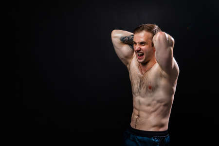 Man on black background keeps dumbbells pumped up in fitness muscle chest black, athlete training strong dumbbell, healthy lifestyle. sportive adult, guy fit hands behind your head a beautiful pressの写真素材